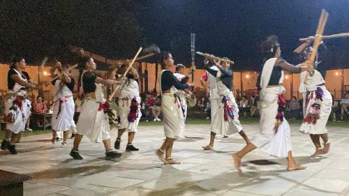 a group of people performing a performance on a stage at Sauraha Tharu Village in Sauraha