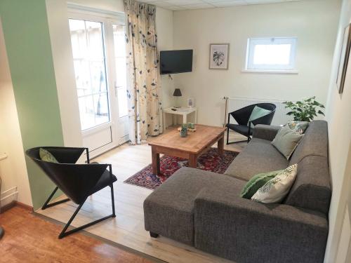a living room with a couch and a table at Hello Zeeland - Halve Maanstraat 10 in Oostkapelle