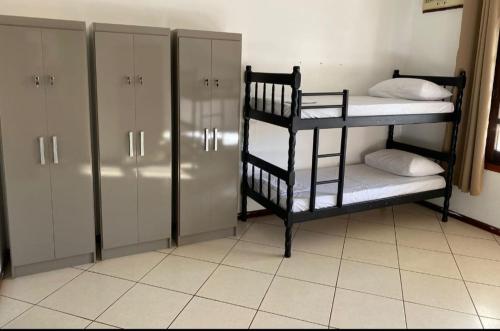 a room with two bunk beds and a locker at Hostel da Dani in Balneário Camboriú