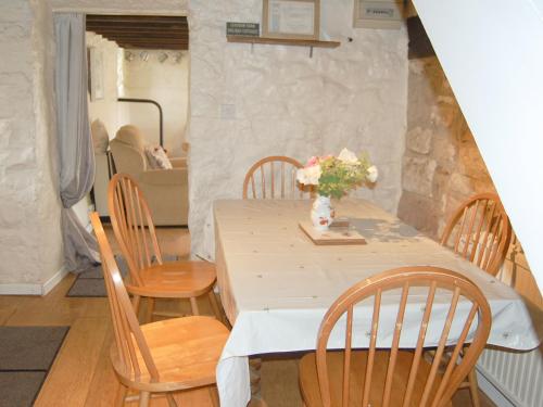 a table with chairs and a vase of flowers on it at Nightingale Cottage - Ukc1570 in Crich