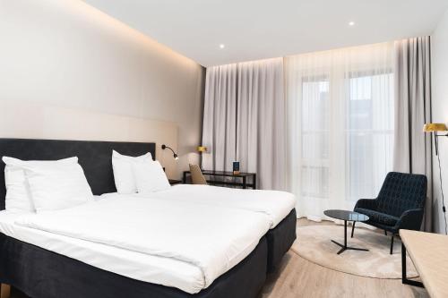 une chambre d'hôtel avec un grand lit et une chaise dans l'établissement Hotel Matts, à Espoo