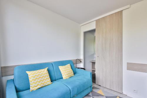 ein Wohnzimmer mit einem blauen Sofa in einem Zimmer in der Unterkunft Louis Vicat 4 - CI - Apartment for 2 Parc Expo Porte de Versailles in Paris