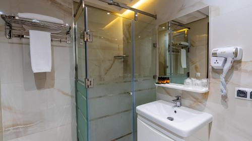 un bagno con lavandino e doccia in vetro di MIRANDA HOTEL - Tanger a Tangeri