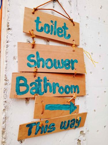 a sign that says toilet shower bathroom this way at Amwani Breeze Beach Camp in El Nido