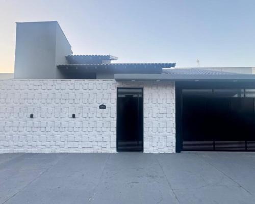un edificio di mattoni bianchi con due porte sopra di Casa ampla próxima ao centro a Dourados