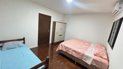 - une chambre avec un lit et un miroir dans l'établissement Casa ampla próxima ao centro, à Dourados