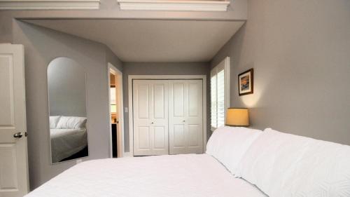 a bedroom with a white bed and a mirror at Family Tides in Cape May