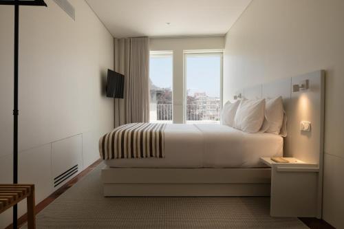 Ένα ή περισσότερα κρεβάτια σε δωμάτιο στο Vila Catarina Luxury Apartments