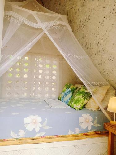 a bed with a canopy in a room at Amwani Breeze in El Nido
