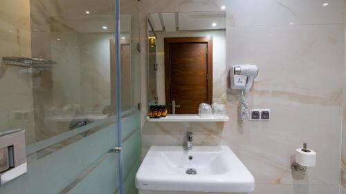 a bathroom with a sink and a phone on the wall at MIRANDA HOTEL - Tanger in Tangier