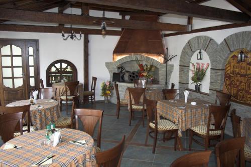un ristorante con tavoli, sedie e un camino di Hotel Old Times a Asenovgrad