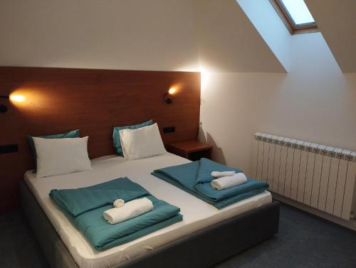 ein Schlafzimmer mit einem Bett mit zwei Kissen darauf in der Unterkunft Vila Plamenac in Divčibare