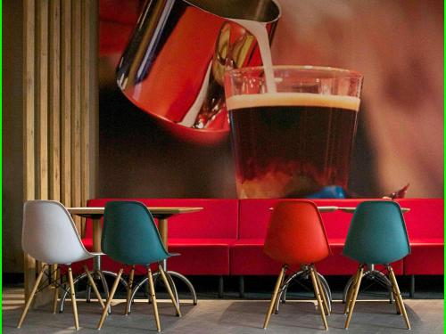 ein Getränk wird in ein Glas neben Stühlen gegossen in der Unterkunft Hotel ibis Lisboa Saldanha in Lissabon