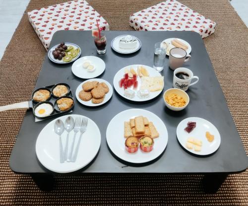 une table avec des assiettes de petit-déjeuner dessus dans l'établissement Nature Hub Homestay Kathmandu, à Kirtipur
