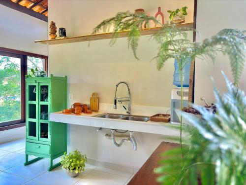 eine Küche mit einem Waschbecken und einem grünen Schrank in der Unterkunft Vila Bambu – by Refúgio Hospedagens in Areia
