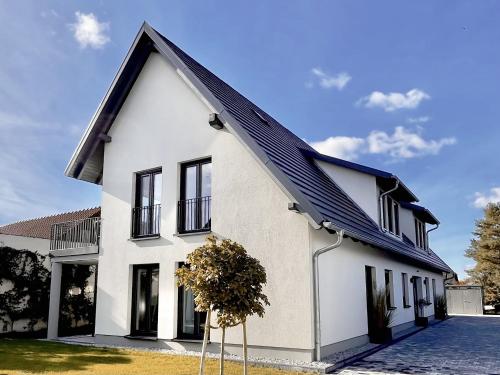 una casa bianca con il tetto nero di WeberHof Appartements a Burg