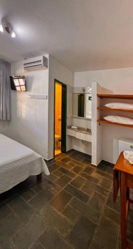 ein Schlafzimmer mit einem Bett und einem Tisch in einem Zimmer in der Unterkunft Pousada in Bombinhas