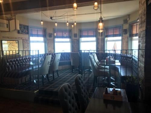 a dining room with a table and chairs and windows at The Grotto in South Shields