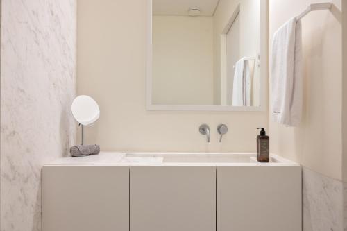 a white bathroom with a sink and a mirror at Vila Catarina Luxury Apartments in Porto