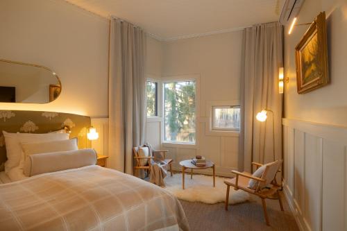 a bedroom with a bed and a table and a window at Aino Private Island Hotel - Adults Only in Rovaniemi