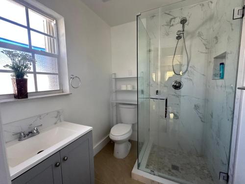 Un baño con ducha, inodoro y lavabo. en Miramar's Studio, en Miramar