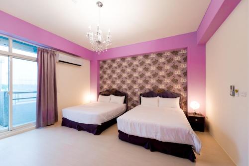 two beds in a room with purple walls at Love Love Taitung in Taitung City