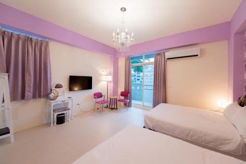 a hotel room with a bed and a tv and a bedroom at Love Love Taitung in Taitung City