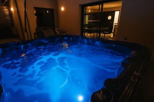 a hot tub in a room with blue lighting at KeschtaLoft - Gîte classé 4 étoiles in Châtenois