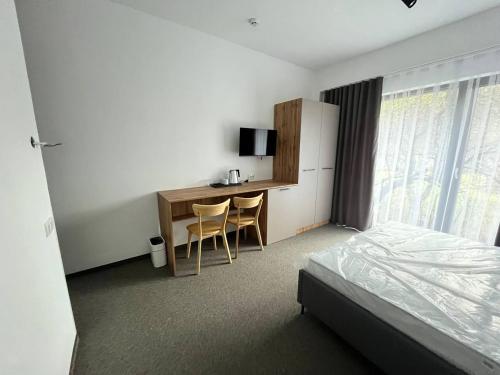 a bedroom with a desk and a bed and a desk with chairs at Casa Piattino in Kvasy