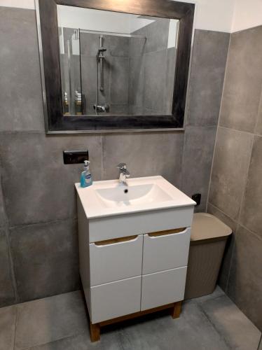 a bathroom with a sink and a mirror and a toilet at Apartament Marco in Koszalin