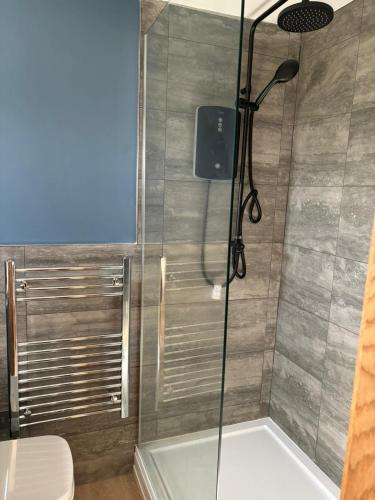 a shower in a bathroom with a glass door at Sandhaven Beach Chalets in South Shields