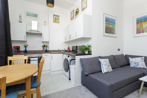 a kitchen and living room with a couch and a table at Air Maison - Dockyard Dreams - Close To Gunwharf! in Portsmouth