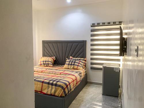 ein Bett mit zwei Kissen darauf in einem Zimmer in der Unterkunft Oystershell Apartments in Gbogije