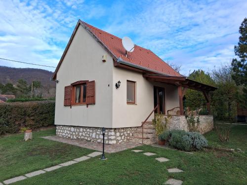 ein kleines weißes Haus mit einem roten Dach in der Unterkunft Cseresznyevirág Vendégházak in Kővágószőlős