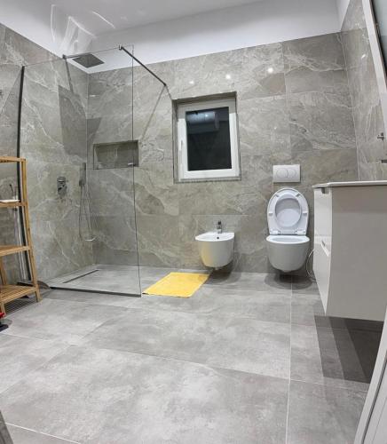 a bathroom with a toilet and a sink and a shower at Ferienhaus Qelia in Durrës