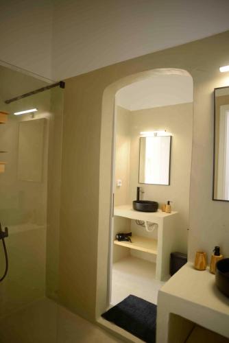 a bathroom with a shower and a sink and a mirror at The endless blue experience in Ios Chora