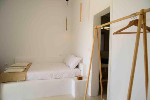 Kleines weißes Zimmer mit einem Bett und einer Leiter in der Unterkunft The endless blue experience in Chora, Ios