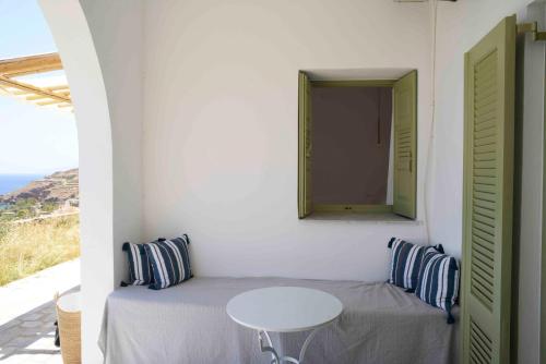 ein kleines weißes Zimmer mit einem Tisch und einem Fenster in der Unterkunft The endless blue experience in Chora, Ios