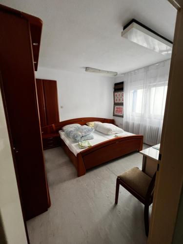 ein Schlafzimmer mit einem großen Bett und einem Stuhl in der Unterkunft TL Gastzimmer 1 in Frankfurt am Main