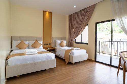 ein Schlafzimmer mit zwei Betten und einem Balkon in der Unterkunft Agricio Farm and Resort 