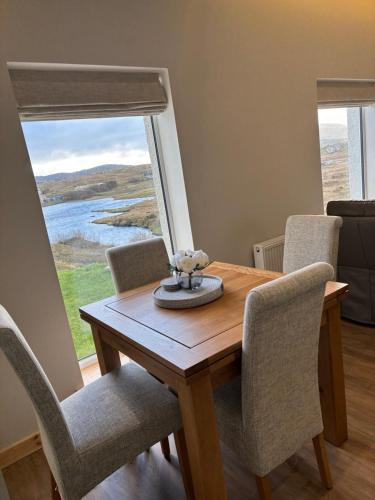 a dining room with a table and chairs and a window at Lighthouse View in Lochboisdale