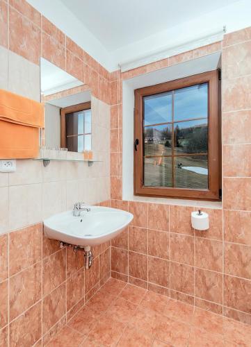 a bathroom with a sink and a window at Penzion Čekanka in Strážné
