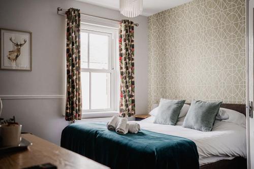 um quarto com uma cama e uma janela em The Railway em Skipton