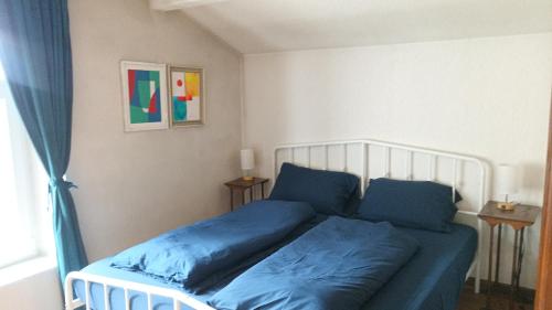 ein Schlafzimmer mit einem Bett mit blauen Laken und einem Fenster in der Unterkunft Charmant gîte vosgien avec 9 chambres pour 22 personnes in Fellering