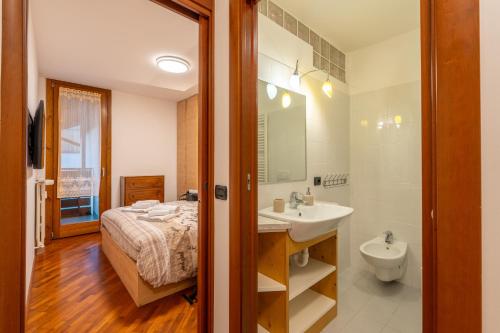 a bathroom with a bed and a sink and a toilet at La Casetta Vintage - Base Milan Cortina 2026 in Bormio