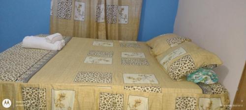 ein Bett mit einer Sitzdecke und Kissen in der Unterkunft Hostel Lençóis em Santo Amaro MA in Santo Amaro