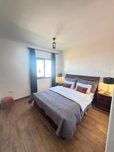 a bedroom with a large bed and a window at Apartamento in M'diq