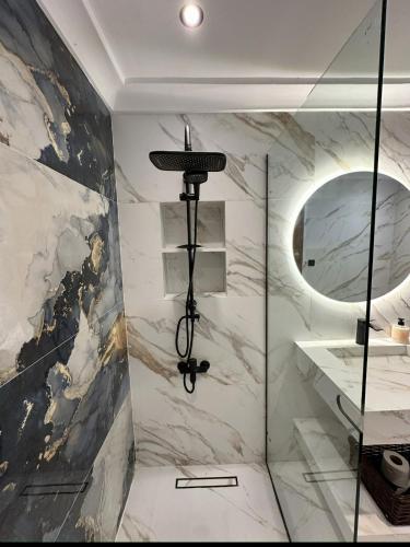 a bathroom with a glass shower and a mirror at Apartamento in M'diq