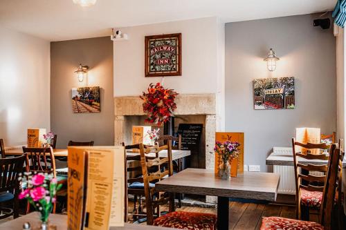 a restaurant with tables and chairs and a fireplace at The Railway in Skipton