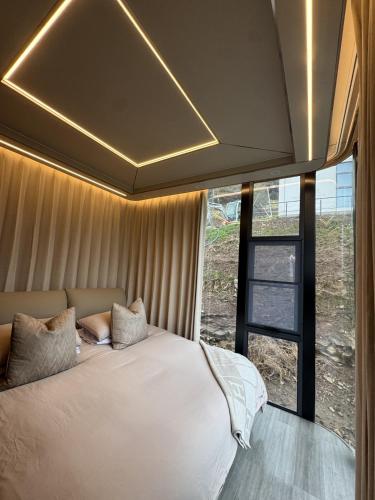 a bedroom with a white bed with a large window at Galactic getaways JUPITER in Prestatyn